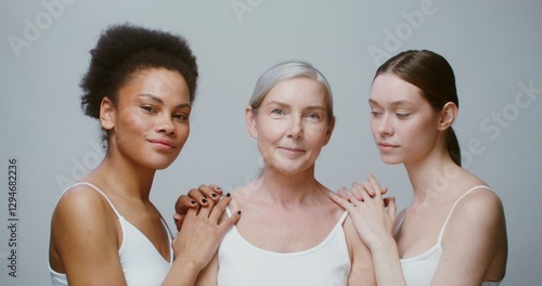 Obraz na płótnie Three emotional models of different ethnicity and age group are smiling broadly looking at the camera and at each other