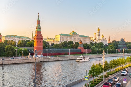 View of Kremlin with Vodovzvodnaya tower, Grand Kremlin Palace from repaired Bolshoy Kamenny Bridge in Moscow city on sunny summer day. Cruise ship sails on the Moscow river