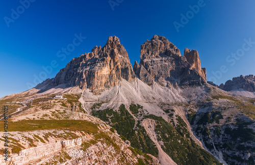 Obraz na płótnie Tre Cime di Lavaredo during sunrise with warm golden light with a person in the foreground w salonie
