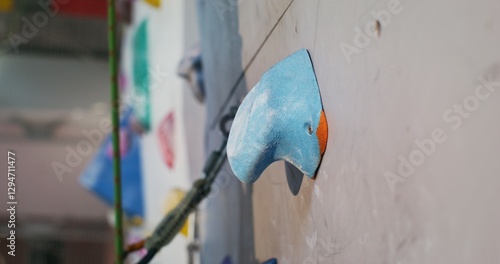 Cuadro en lienzo A man's foot in rubberized sports shoes steps on an artificial unevenness imitating a stone on a climbing wall, close-up
