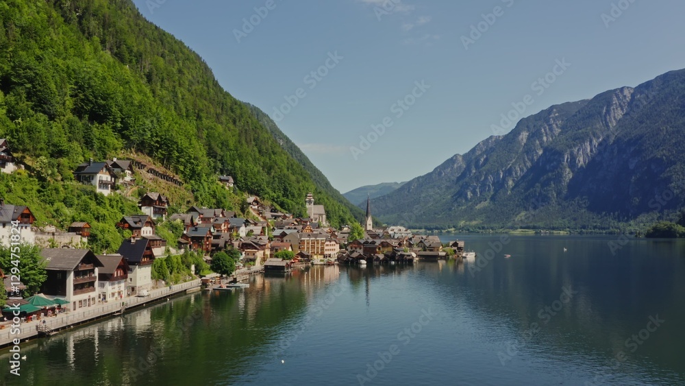 Non-white village with traditional houses, located on the shore of a picturesque lake, in a lowland between the Alps. Austria, Hallstatt, drone video Non-white village with traditional houses, located on the shore of a picturesque lake, in a lowland between the Alps. Austria, Hallstatt, drone video