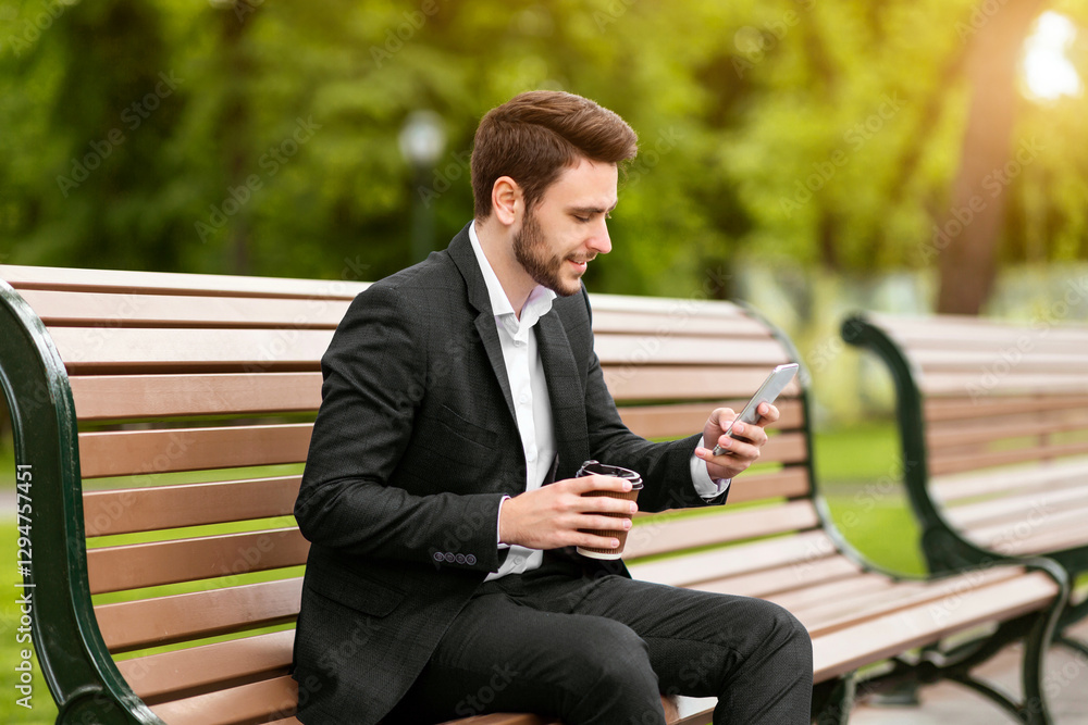 Handsome office employee having coffee to go and browsing web via smartphone on bench at city park Handsome office employee having coffee to go and browsing web via smartphone on bench at city park