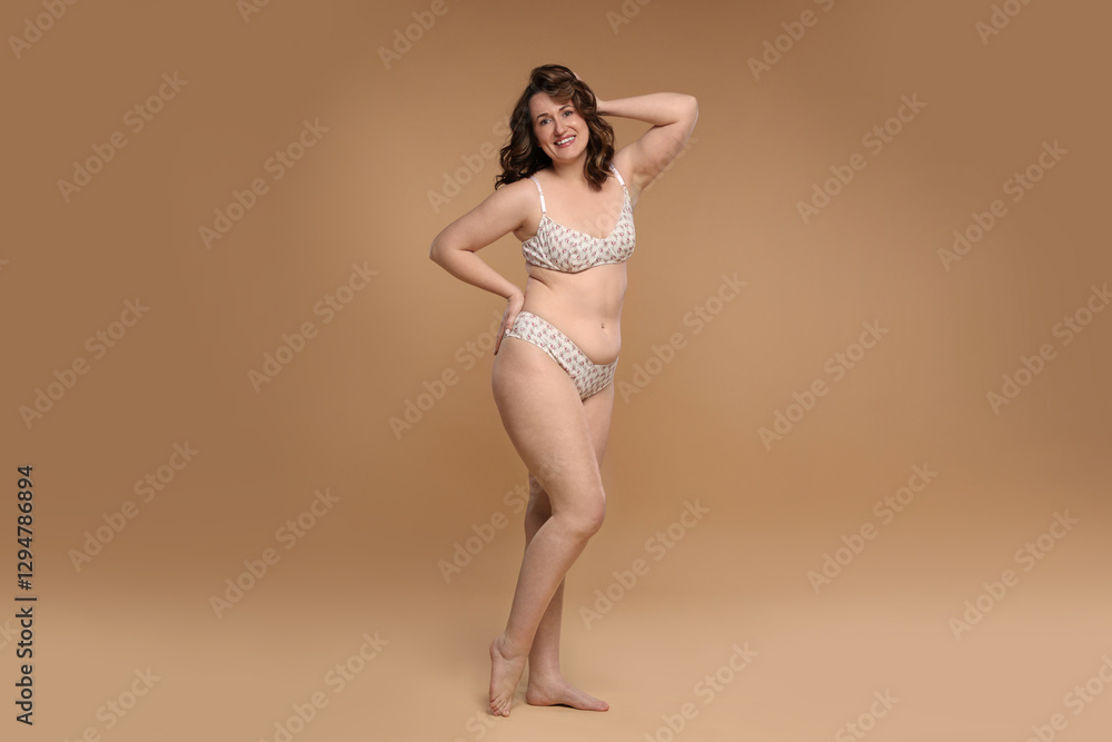 Fototapeta premium Beautiful woman in underwear on dark beige background. Cellulite problem