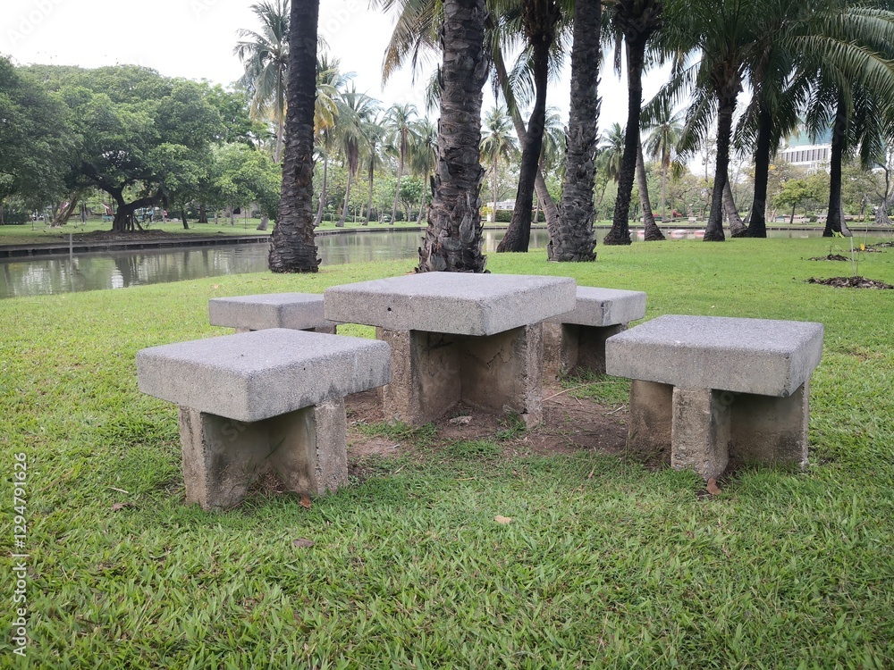 Stone Table and Stools in a Tranquil Park Setting with Palm Trees Stone Table and Stools in a Tranquil Park Setting with Palm Trees