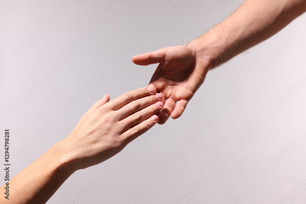Man offering helping hand to his friend on light grey background, closeup Man offering helping hand to his friend on light grey background, closeup