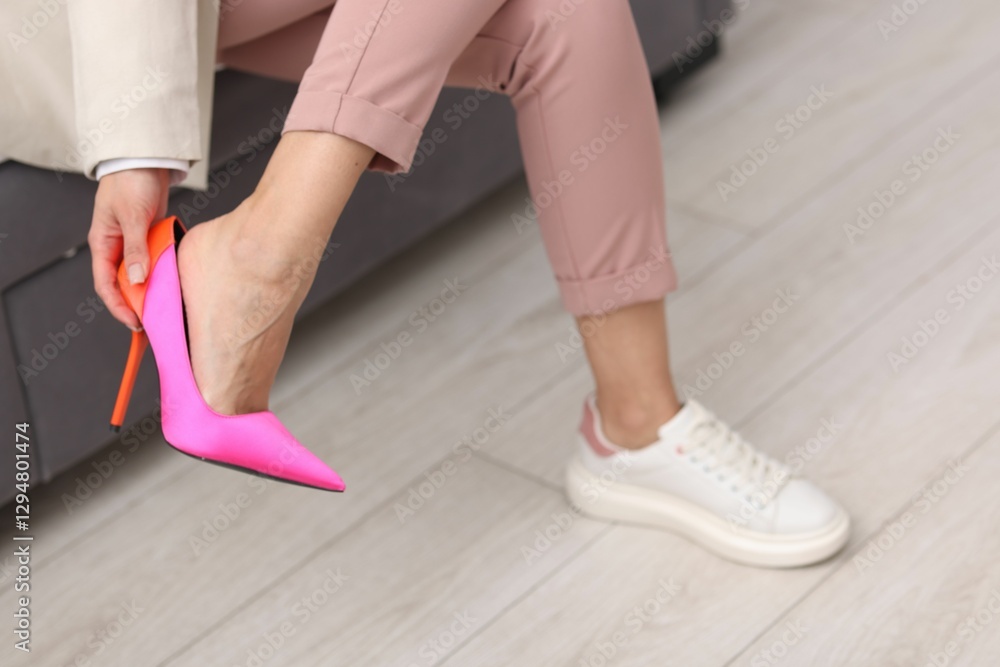 Woman changing shoes on sofa indoors, closeup Woman changing shoes on sofa indoors, closeup