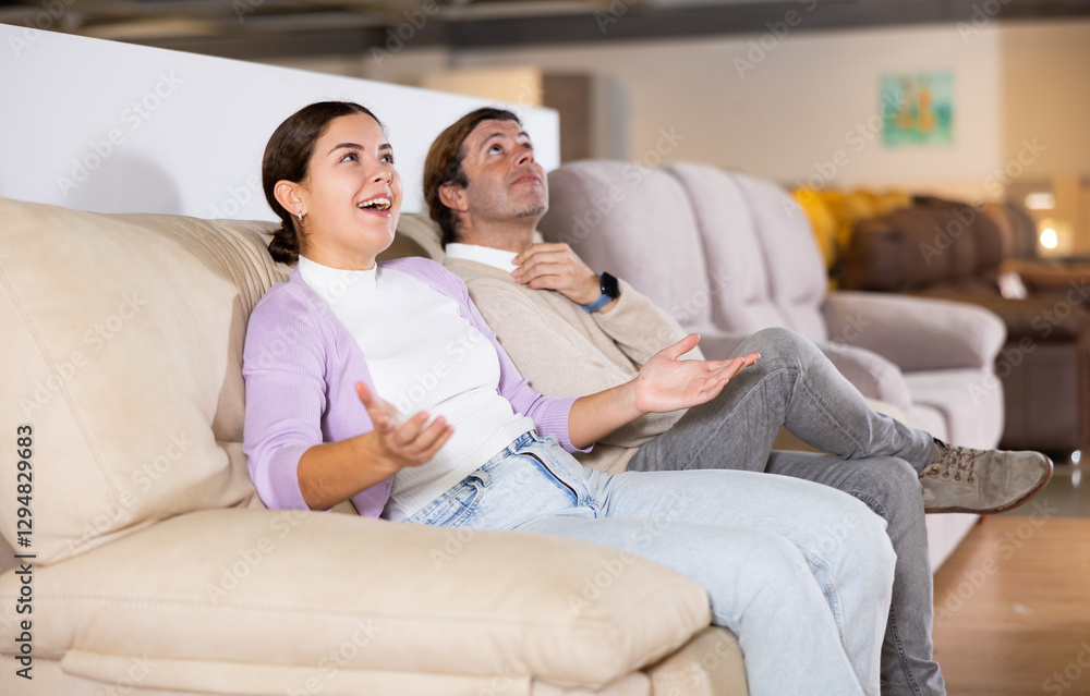 Potential buyers trying and checking a new sofa Potential buyers trying and checking a new sofa