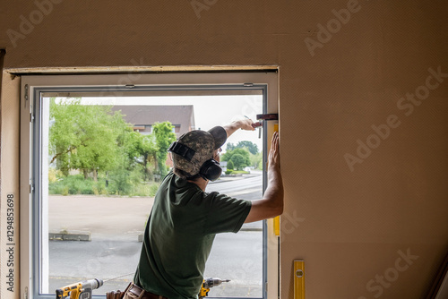 Carpenter Installing an Energy-Efficient Window in a House Renovation.
