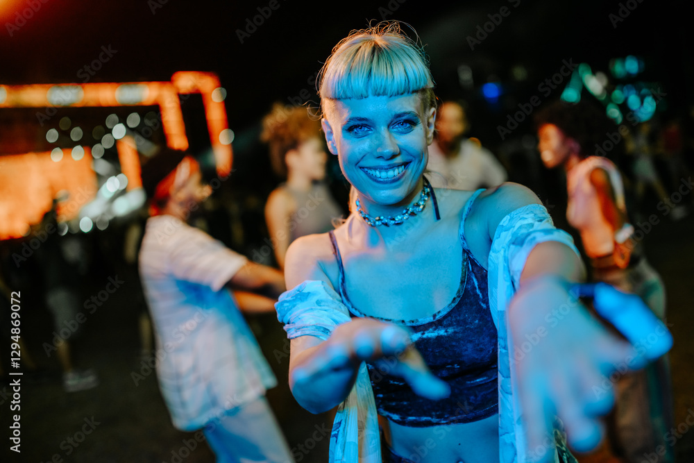 Fototapeta premium Young woman dancing and reaching out at a music festival