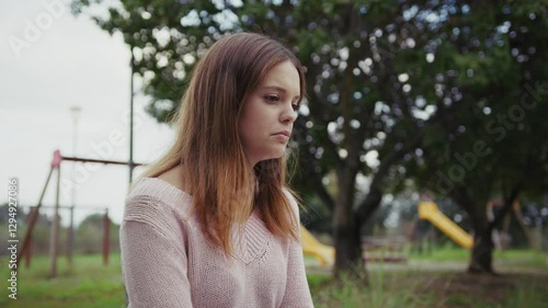 Sad And Lonely Girl Sitting In Park Bench Outdoors