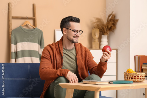 Handsome man with apple sit...