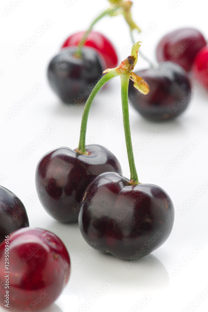 Fresh cherries arranged on a white background with vibrant red and dark purple hues Fresh cherries arranged on a white background with vibrant red and dark purple hues