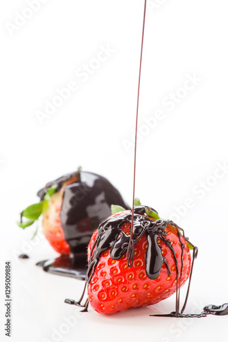 Strawberries drizzled with chocolate sauce on a white background