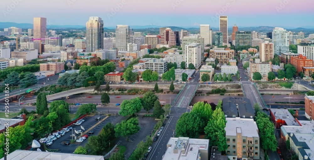 Obraz premium High-angle view of Portland, Oregon's downtown skyline at twilight. Urban landscape with buildings, roads, and vehicles. Beautiful city scene. Oregon, USA