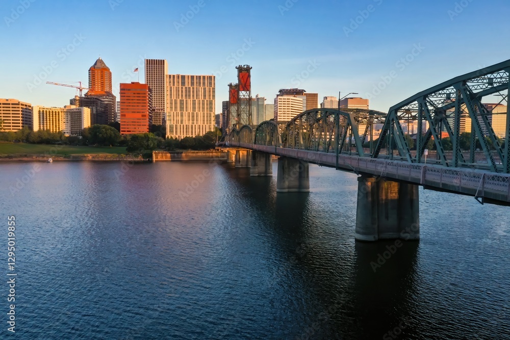Fototapeta premium Portland, Oregon skyline at dawn, with the Hawthorne Bridge over the Willamette River. Cityscape, bridge, and water. Portland, Oregon, USA