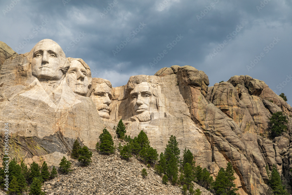 Fototapeta premium The Carved Heads of the Presidents on Mount Rushmore Rising Above the Tree Line in Black Hills National Forest on a Cloudy Day, South Dakota, United States