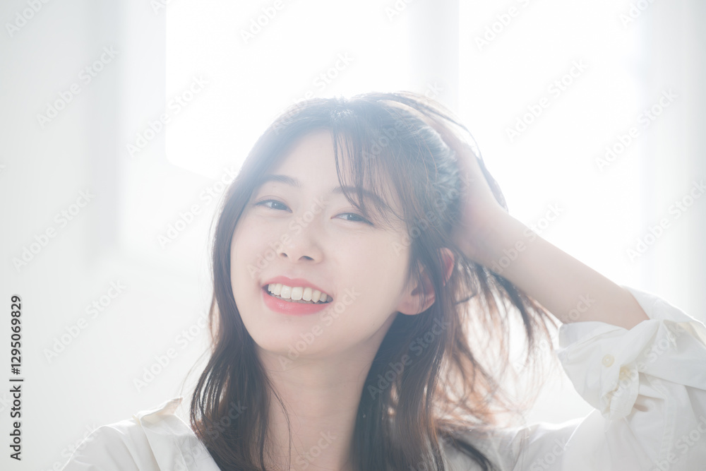 髪をかき上げる爽やかな女性のカメラ目線 ヘアケアや美容やビューティー 髪をかき上げる爽やかな女性のカメラ目線 ヘアケアや美容やビューティー
