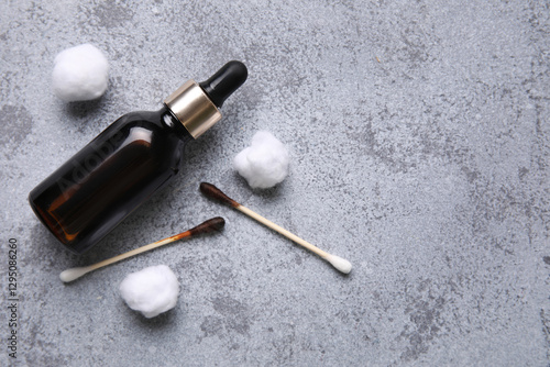 Bottle with iodine, cotton swabs and wool on grey grunge background, closeup photo