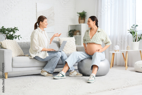 Young doula with laptop and...