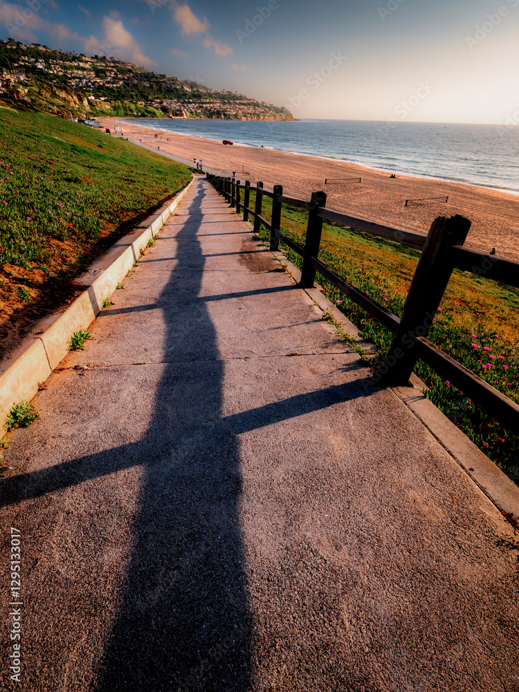 Redondo Beach walking ramp leading down to the beach on a beautiful day with blue sky, few scattered clouds with an empty beach and a clear view of the Palos Verdes Peninsula