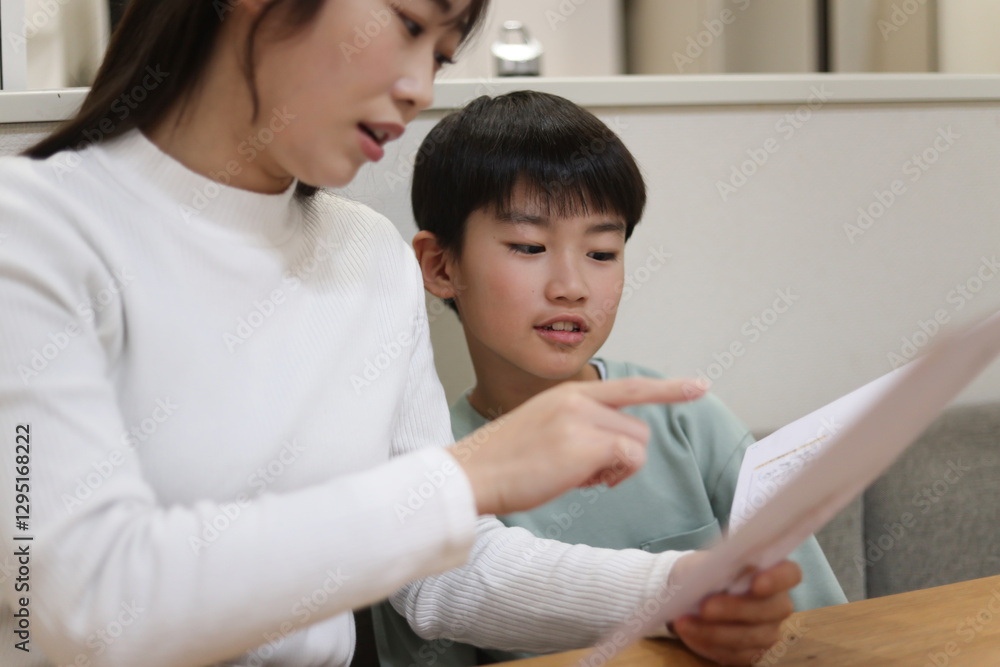 通知表を見て困った顔の母親 通知表を見て困った顔の母親