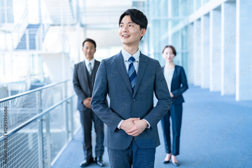 オフィスで微笑む若手のビジネスマン オフィスで微笑む若手のビジネスマン