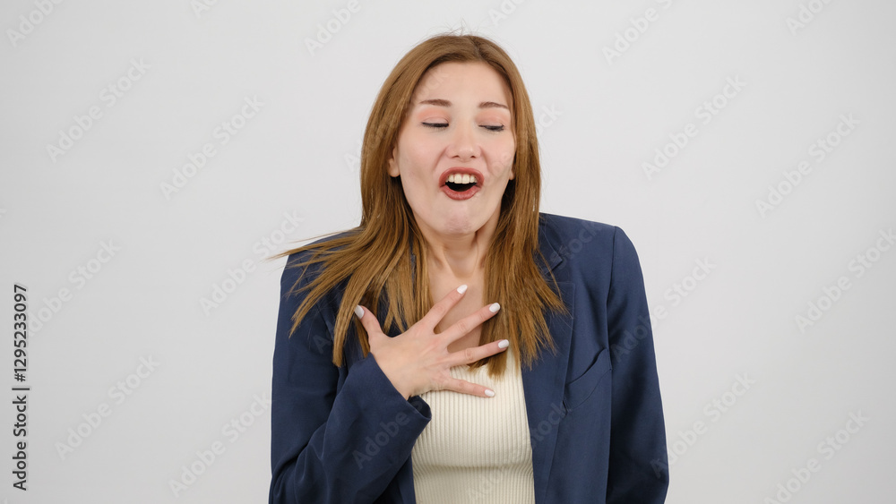 In a studio setting, a young businesswoman wearing a suit is standing in front of a white background, gagging as if feeling nauseous and looking at the camera In a studio setting, a young businesswoman wearing a suit is standing in front of a white background, gagging as if feeling nauseous and looking at the camera