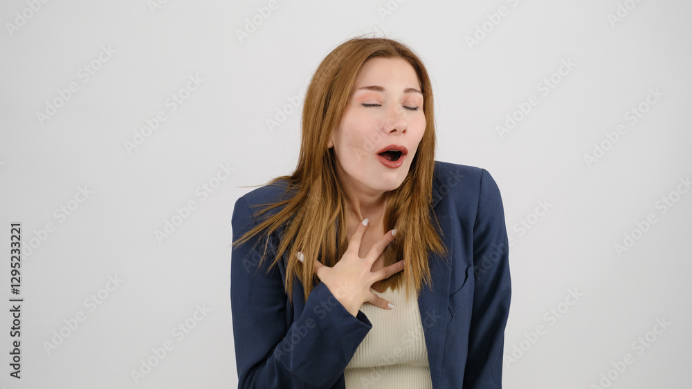 In a studio setting, a young businesswoman wearing a suit is standing in front of a white background, gagging as if feeling nauseous and looking at the camera In a studio setting, a young businesswoman wearing a suit is standing in front of a white background, gagging as if feeling nauseous and looking at the camera