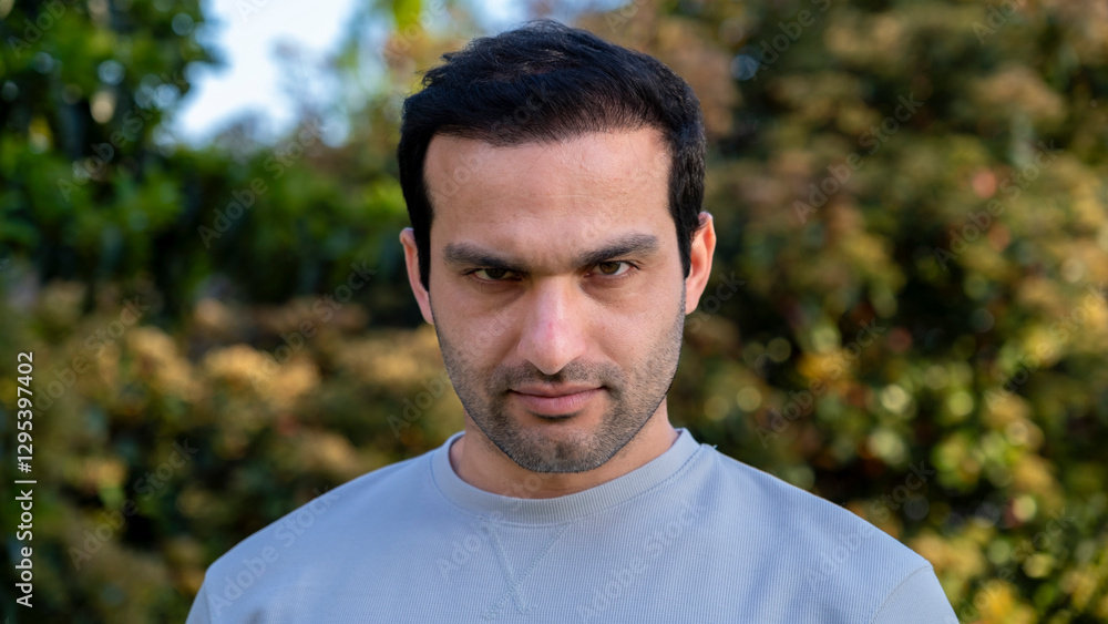 In the park, a man looks at the camera and makes gestures and facial expression that show extreme anger and frustration In the park, a man looks at the camera and makes gestures and facial expression that show extreme anger and frustration