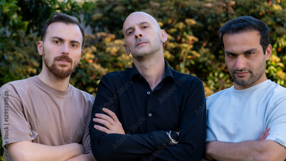 Obraz premium Close-up of three middle-aged businessmen standing in a wooded area, arms crossed, with determined gazes reflecting business focus