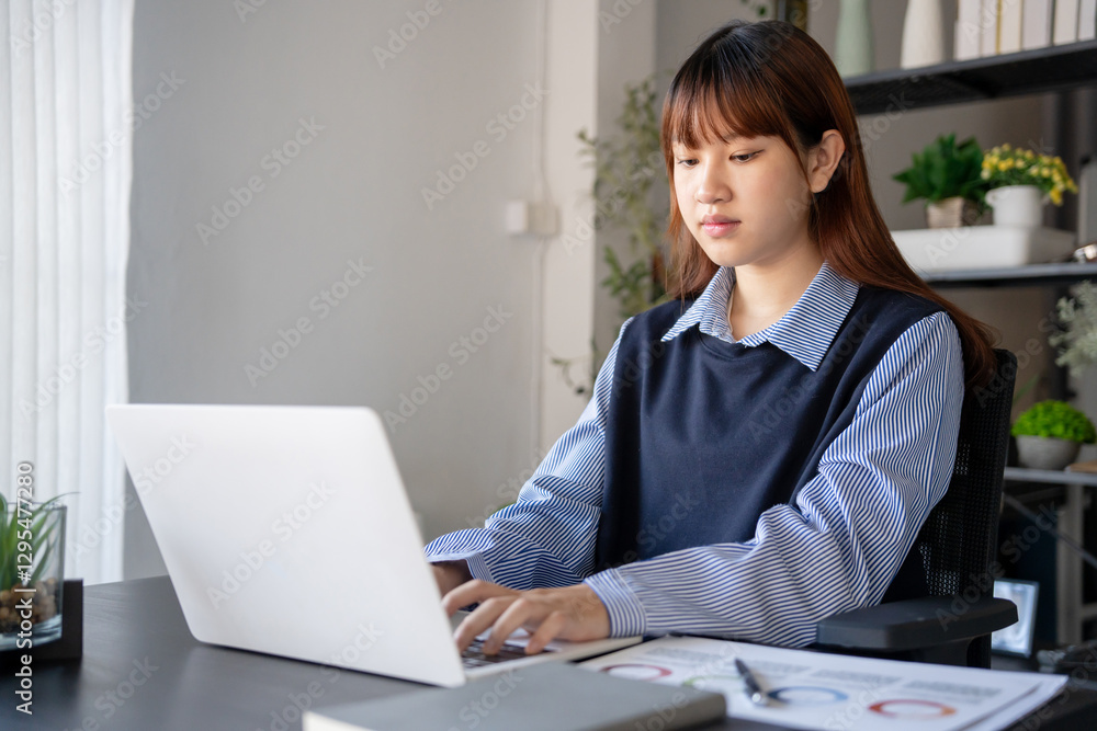 Asian businesswoman using laptop doing documents Asian businesswoman using laptop doing documents