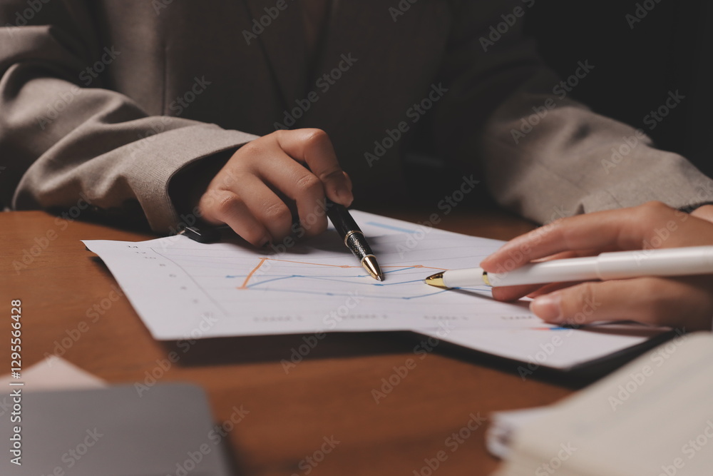 Group of confident business people point to graphs and charts to analyze market data, balance sheet, account, net profit to plan new sales strategies to increase production capacity. Group of confident business people point to graphs and charts to analyze market data, balance sheet, account, net profit to plan new sales strategies to increase production capacity.