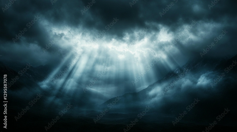 Fototapeta premium Dramatic dark moody landscape with light rays piercing through clouds over misty mountains.