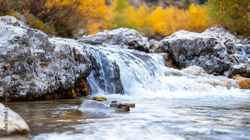 Glistening stream of water flowing over smooth rocks surrounded by vibrant autumn foliage and nature : Generative AI