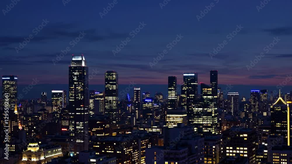 The skyline of a bustling city is showcased at dusk, featuring illuminated skyscrapers against a backdrop of stunning sunset colors.