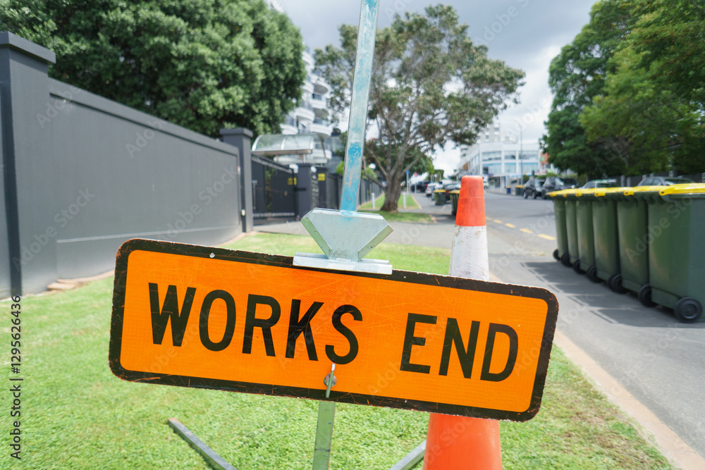 “Works End” road sign and orange traffic cones on the roadside. Roadworks in Auckland.