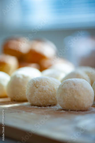 Wallpaper Mural Soft dough balls rest on a wooden board, ready for baking, with golden brown muffins in the blurred background. Torontodigital.ca