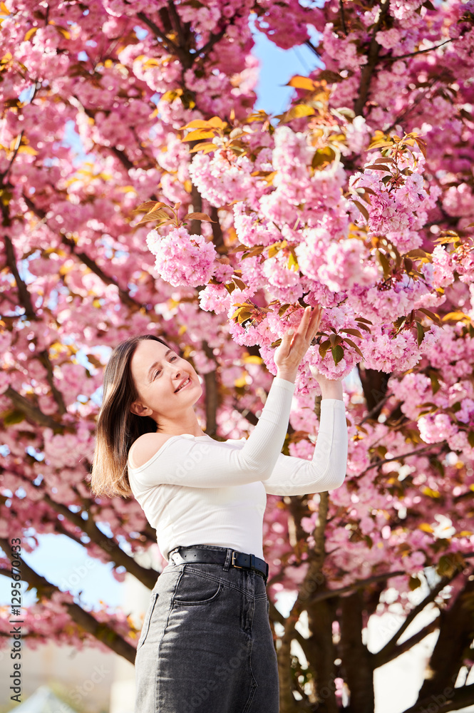 Woman allergic enjoying after treatment from seasonal allergy at spring. Portrait of happy beautiful woman smiling in front of blooming sakura tree at springtime. Spring allergy concept. Woman allergic enjoying after treatment from seasonal allergy at spring. Portrait of happy beautiful woman smiling in front of blooming sakura tree at springtime. Spring allergy concept.