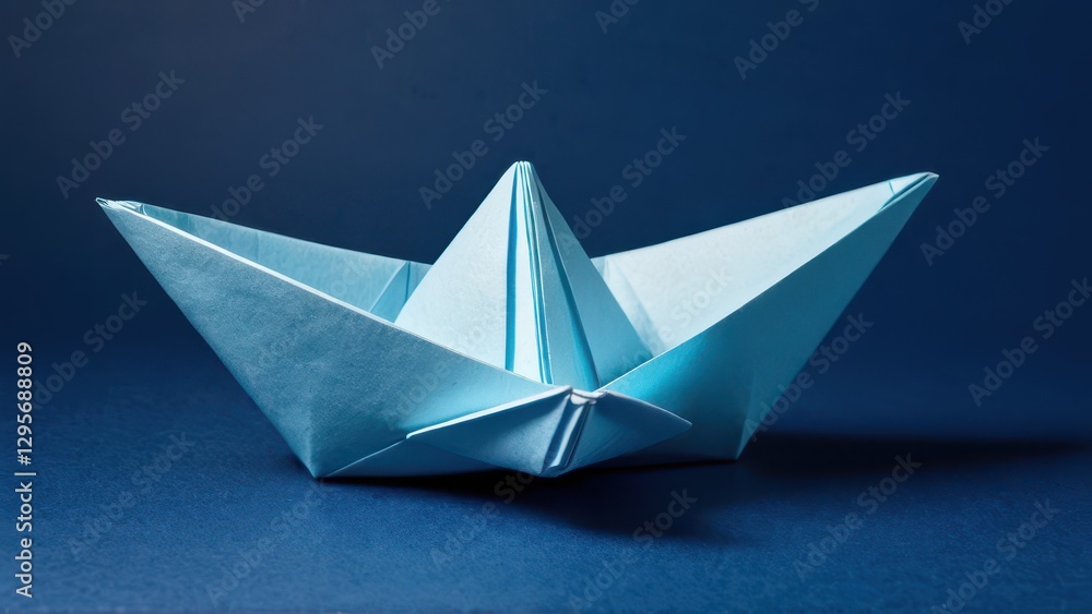 Obraz premium a delicate blue origami boat rests gracefully against a deep blue backdrop