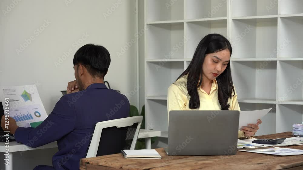 Collaborative Workflow: A focused business duo diligently reviews reports and utilizes modern technology, captured in a clean and well-lit workspace. Collaborative Workflow: A focused business duo diligently reviews reports and utilizes modern technology, captured in a clean and well-lit workspace.
