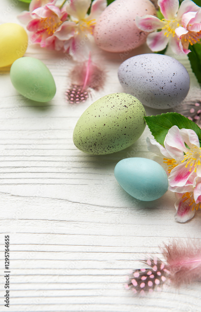Colorful easter eggs and spring flowers creating festive border on white wood Colorful easter eggs and spring flowers creating festive border on white wood