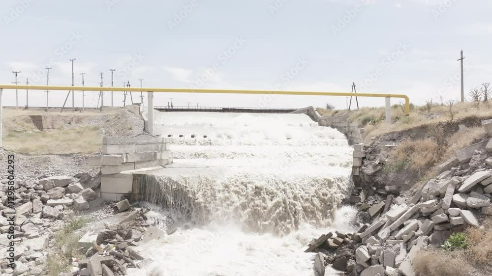 Splashing White Water Cascading Over a Waterfall Edge of concrete water spillway at sunny day Splashing White Water Cascading Over a Waterfall Edge of concrete water spillway at sunny day