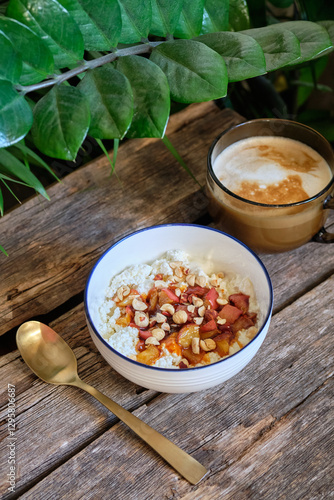 Cottage cheese with hazelnuts and caramelized apples. wooden background, side view	
