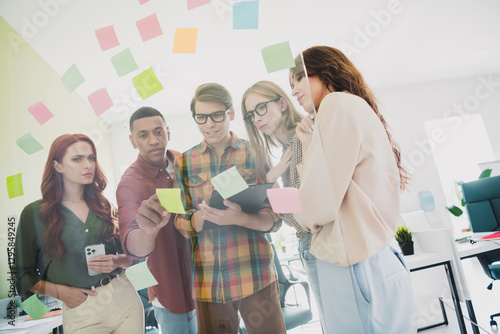 Photo of group successful specialists searching ways to make process cheaper cooperation working using paper stickers indoors office photo