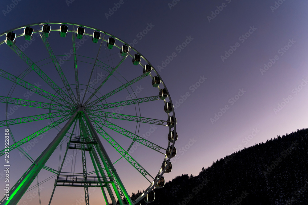 Fototapeta premium Ferris wheel among snowy mountains