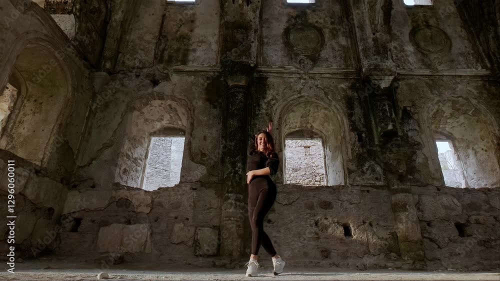 A historic and touristic site with towering ceilings and stone walls becomes the stage for a dancer. The fusion of movement and architecture creates a striking visual composition. A historic and touristic site with towering ceilings and stone walls becomes the stage for a dancer. The fusion of movement and architecture creates a striking visual composition.