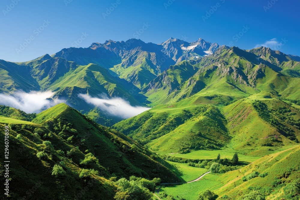 Obraz premium A breathtaking mountain landscape with lush green hills, towering peaks, and a clear blue sky, creating a serene and picturesque natural scene.