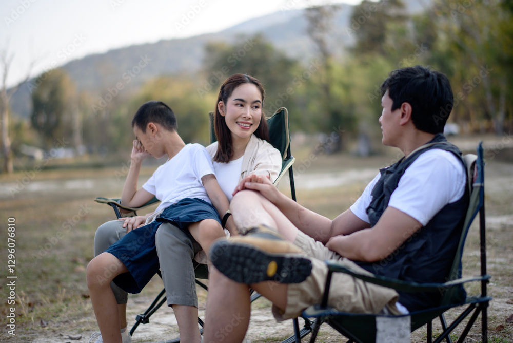A loving family enjoys a peaceful evening outdoors during their camping trip A loving family enjoys a peaceful evening outdoors during their camping trip