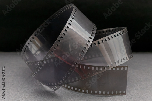 Tangled 35mm film strip isolated on grey surface with dark background