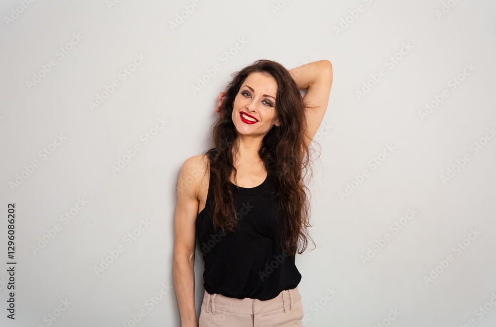 Positive relaxing make-up woman with red lipstick looking happy in black top on blue studio empty copy space background. Expression portrait Positive relaxing make-up woman with red lipstick looking happy in black top on blue studio empty copy space background. Expression portrait